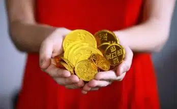 person holding gold-colored ching coins