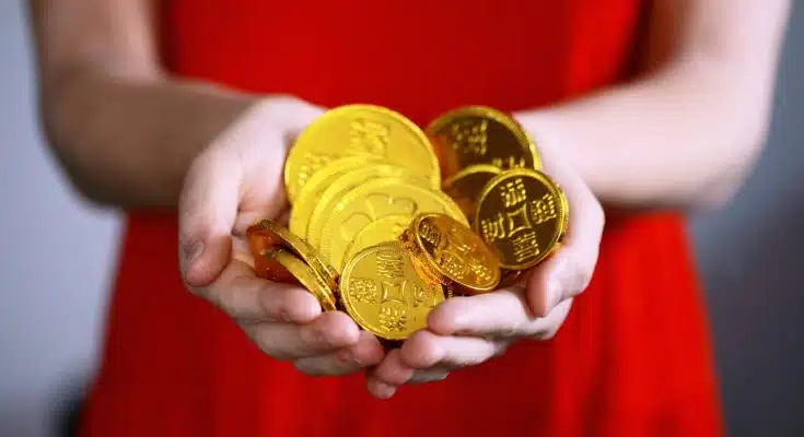 person holding gold-colored ching coins